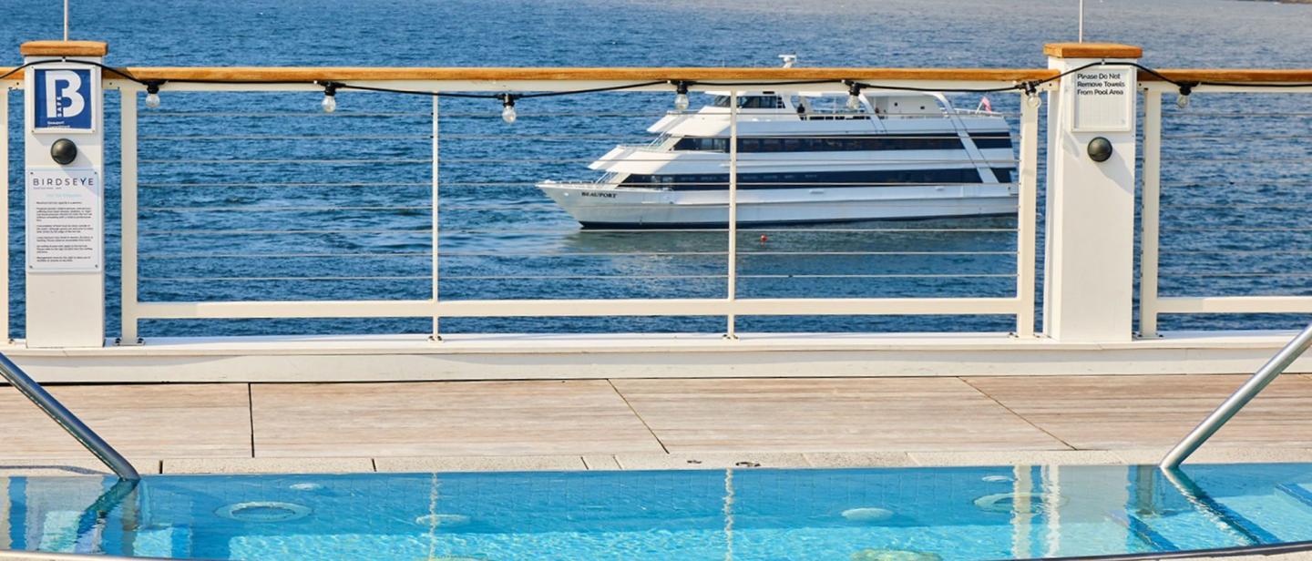 Cruise ship railing, sea view, boat sailing in background.