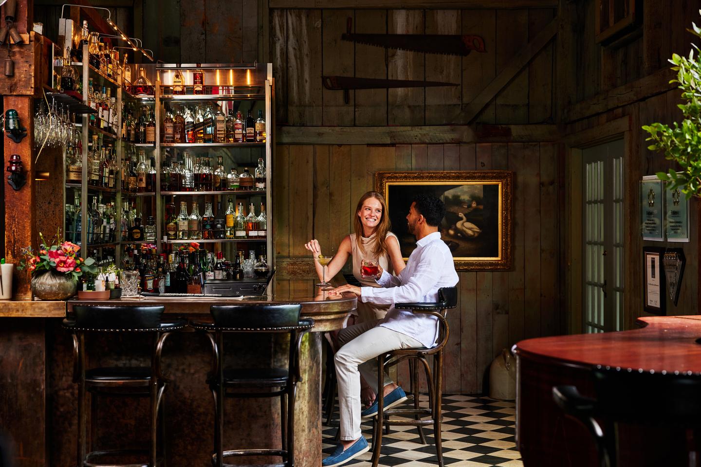 Cozy bar scene with two people chatting at the counter.