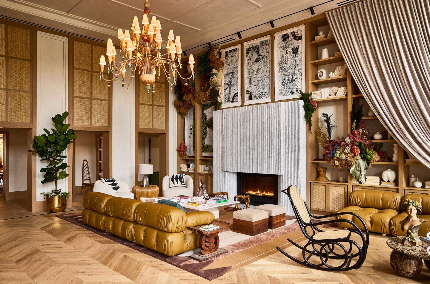 Luxurious living room with leather sofa, chandelier, and large fireplace.Lobby1