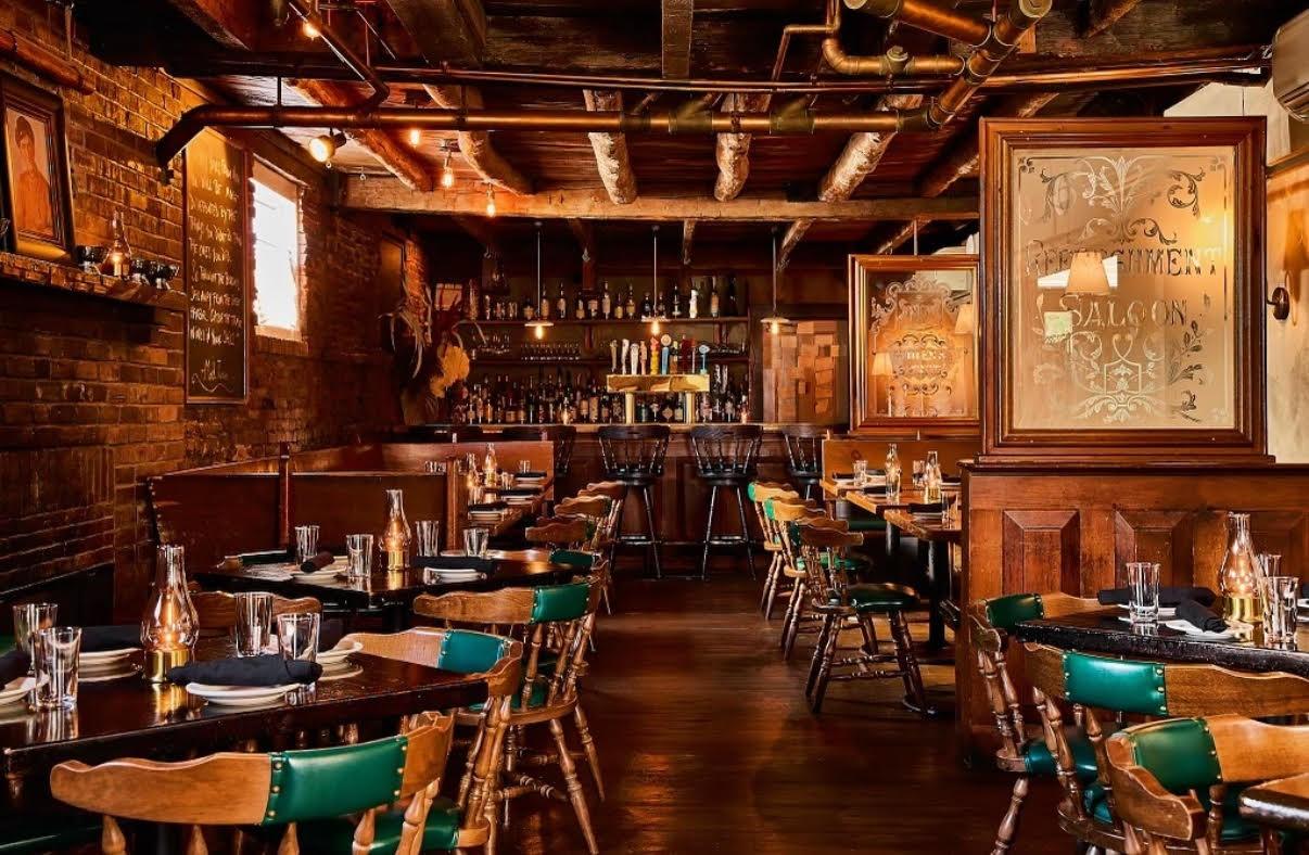 Cozy restaurant interior with wooden tables and dim lighting.