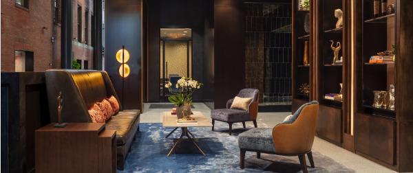 Modern lobby with soft lighting, stylish seating, and elegant decor on shelves.