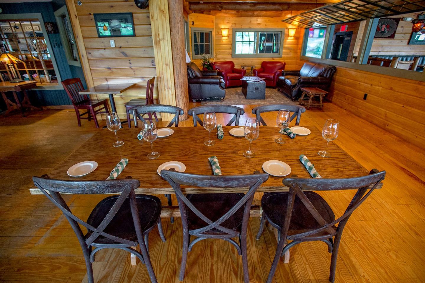Rustic dining room with a set wooden table and cozy seating area with armchairs.