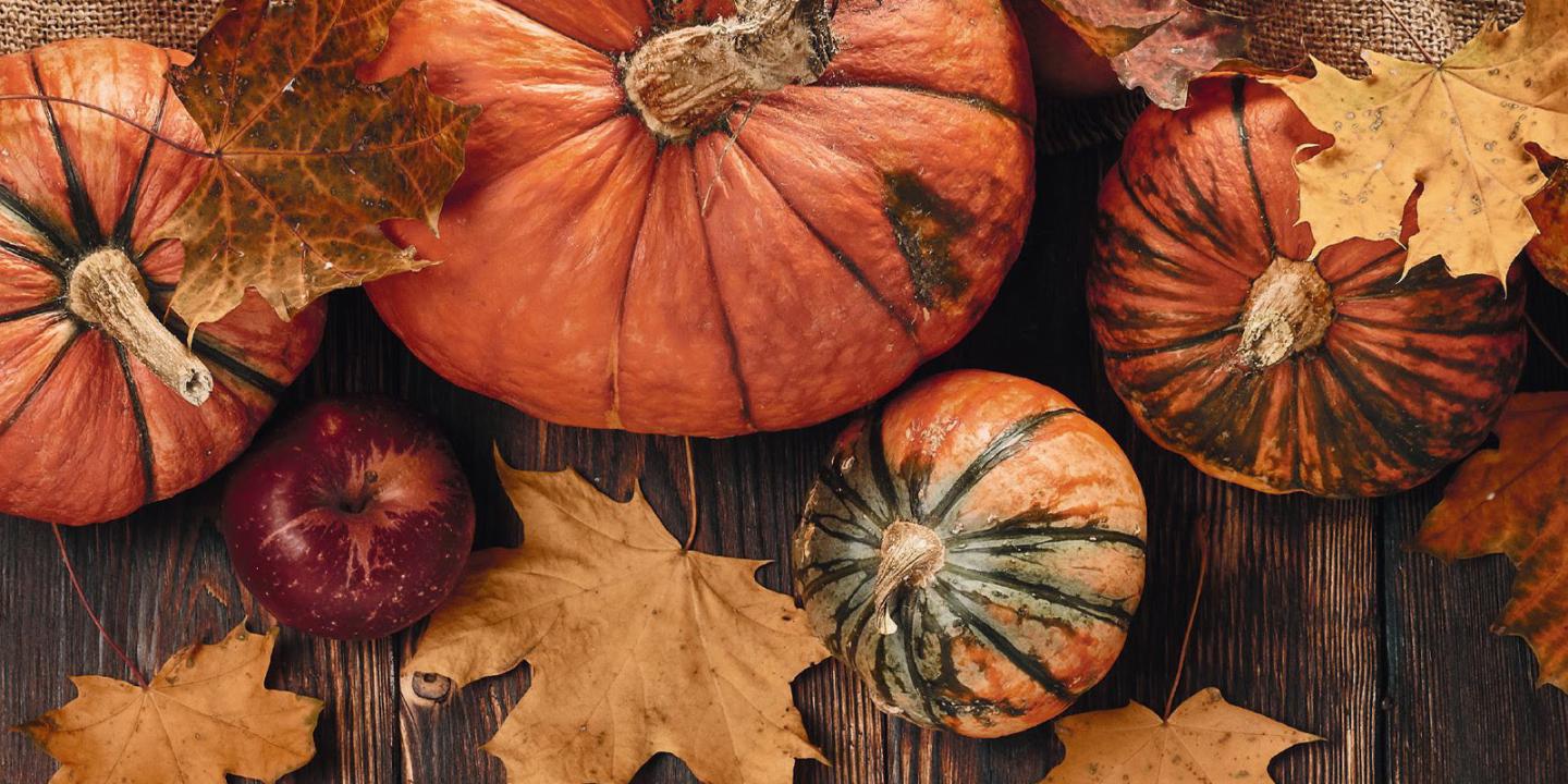 Autumn pumpkins and leaves on a wooden table.