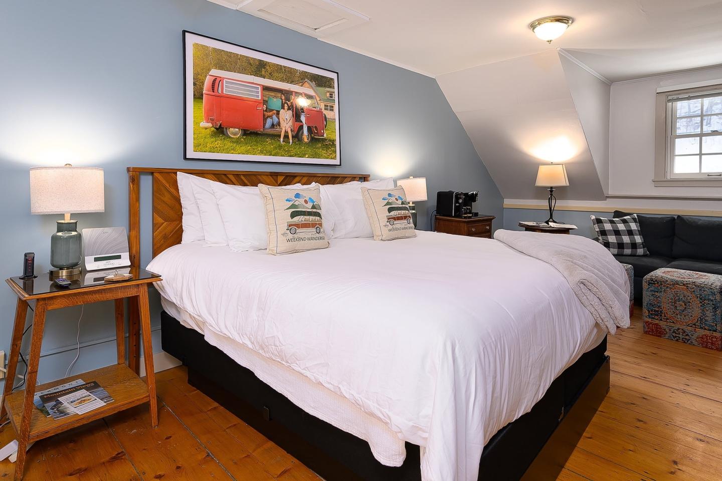 Cozy bedroom with a large bed, blue walls, and warm lighting.