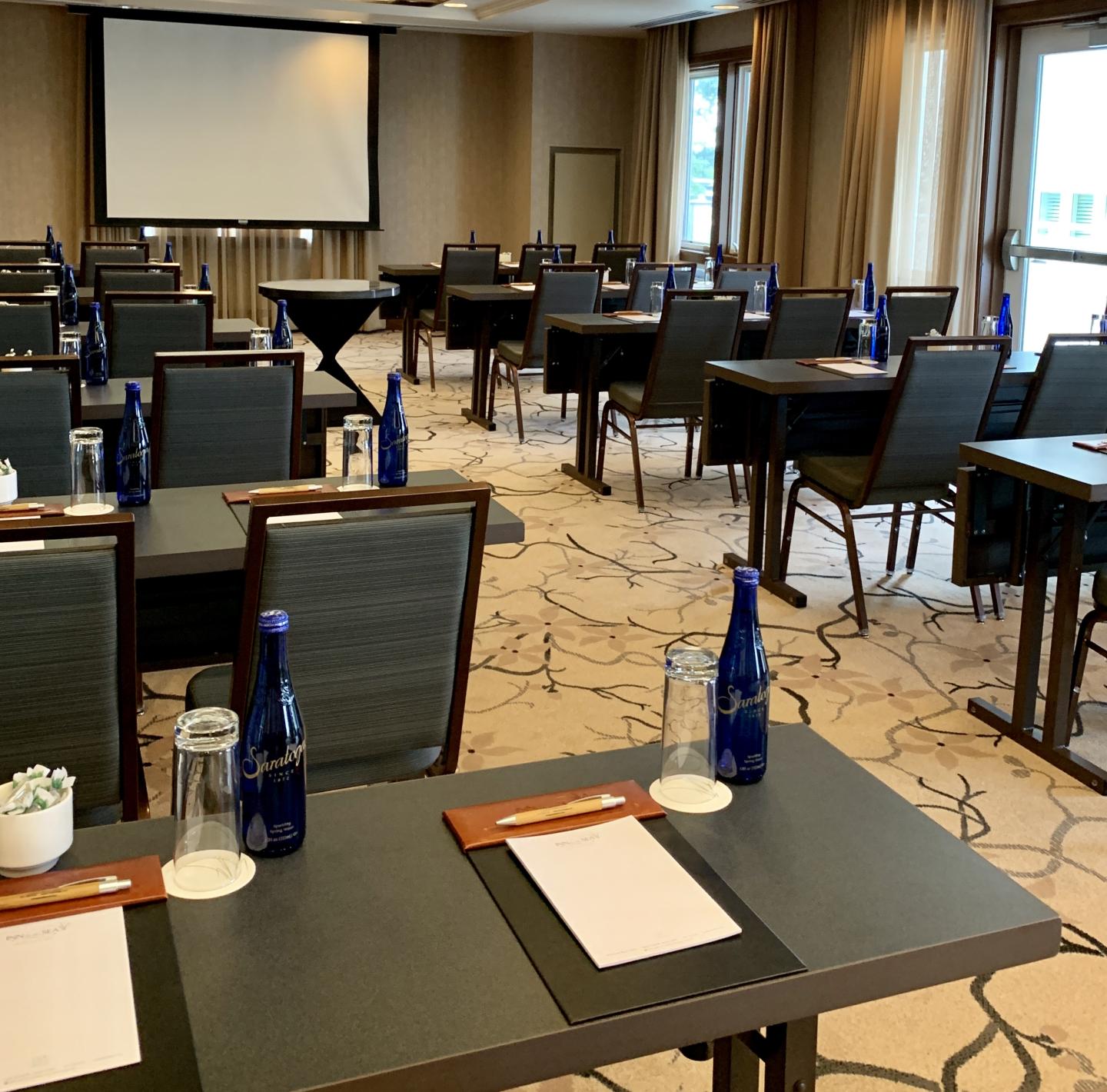 Conference room with tables, chairs, and blue water bottles.