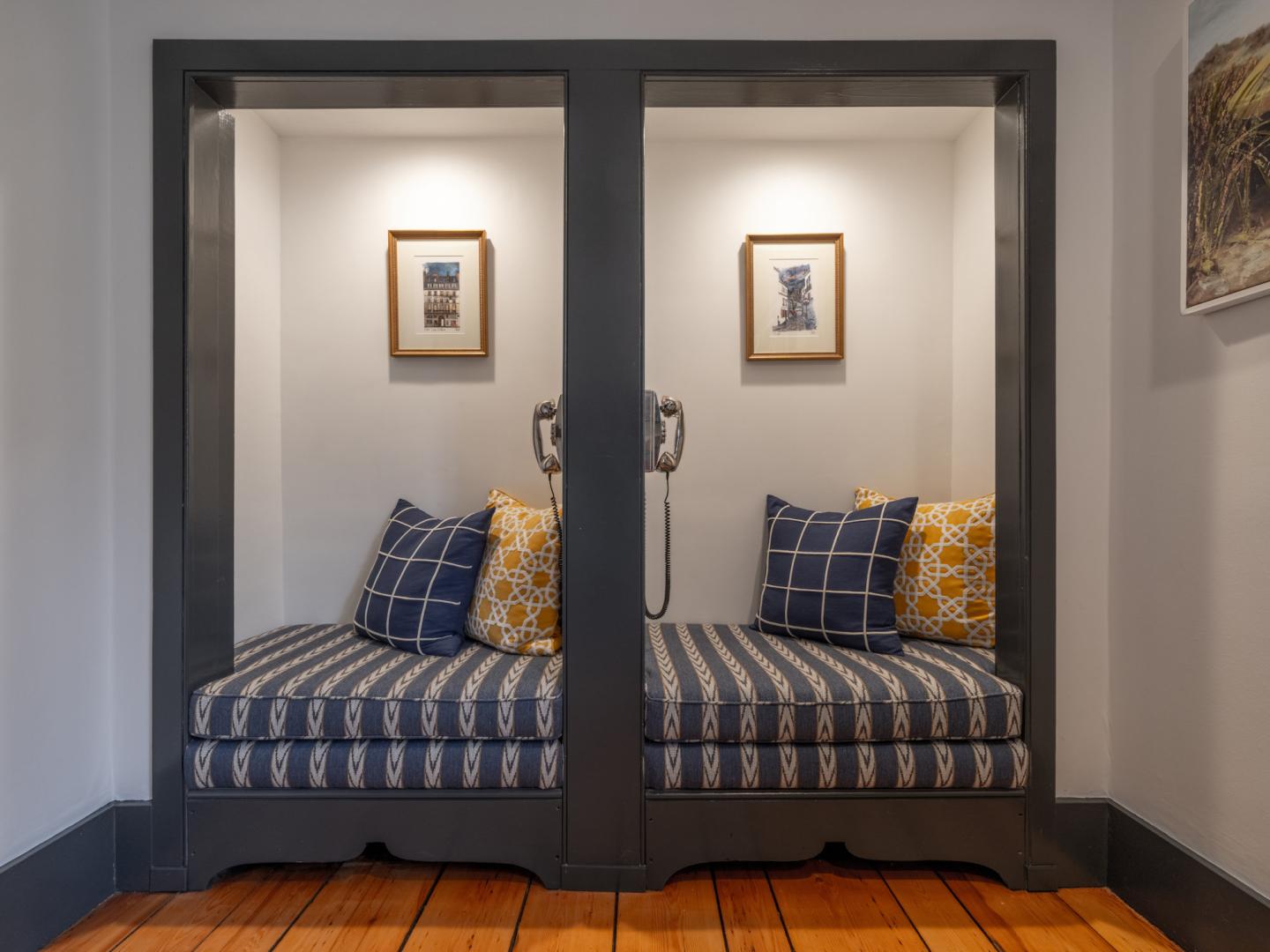 Two cozy gray alcove seats with striped cushions and decorative pillows.
