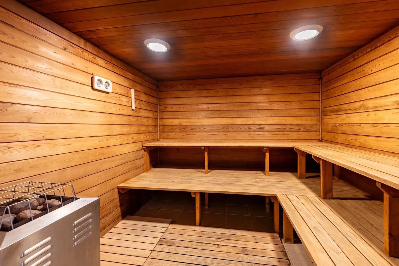 Cozy wooden sauna room with benches and soft lighting.
