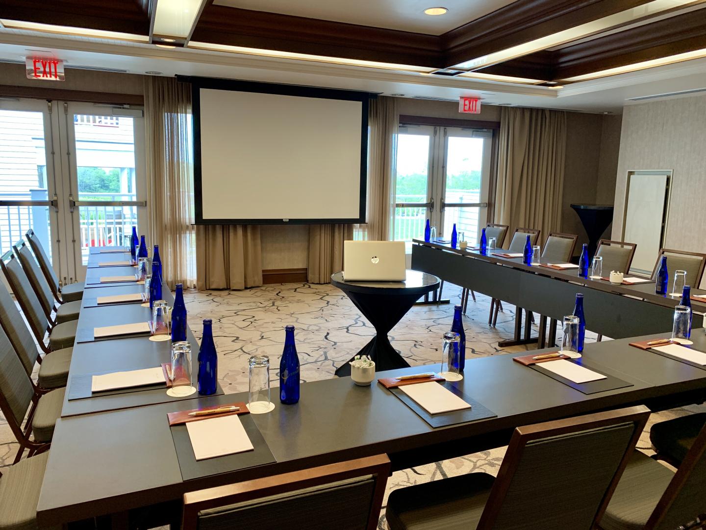 Conference room with a U-shaped table setup facing a projection screen.