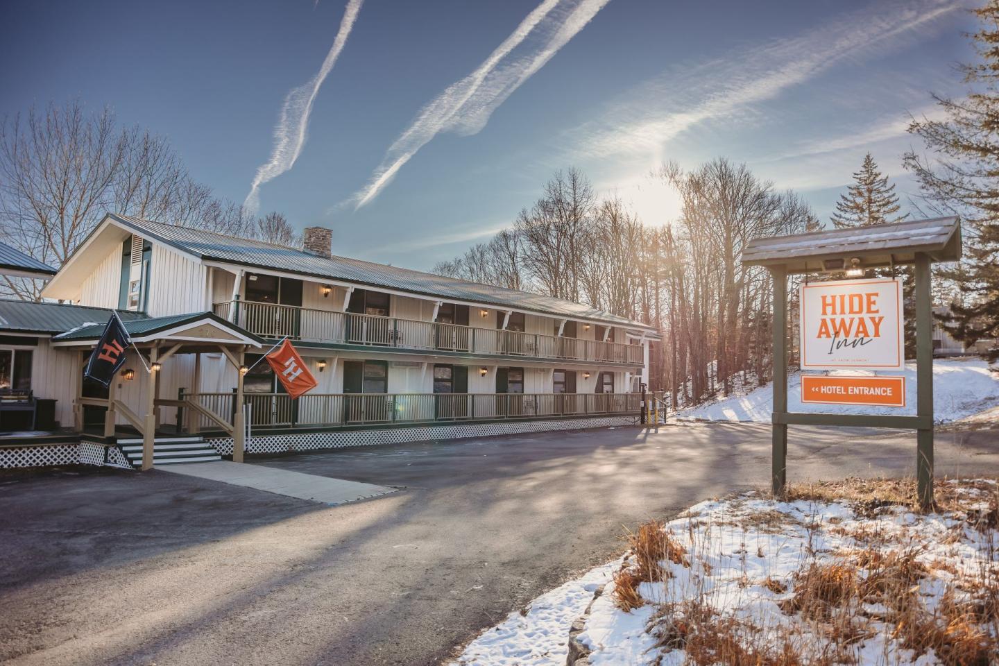 Two-story hotel in snowy landscape under clear blue sky.