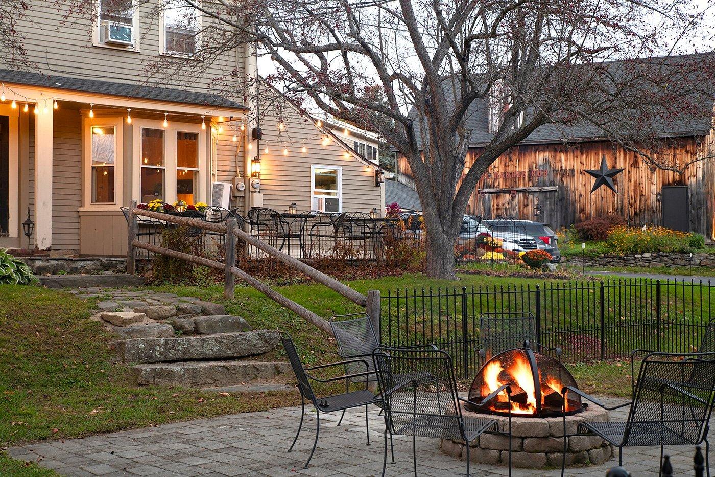 Cozy backyard with fire pit, chairs, and string lights at dusk.