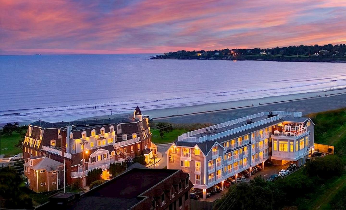 Beachfront hotel at sunset with vibrant skies and ocean views.