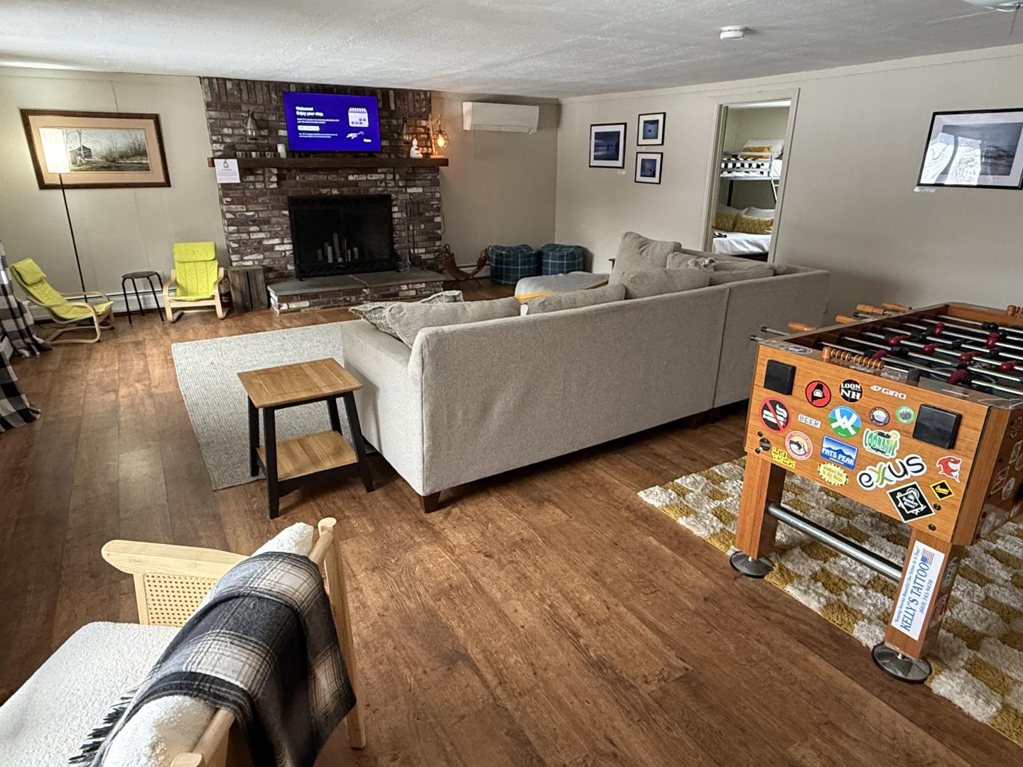Cozy living room with a large sofa, foosball table, and stone fireplace.