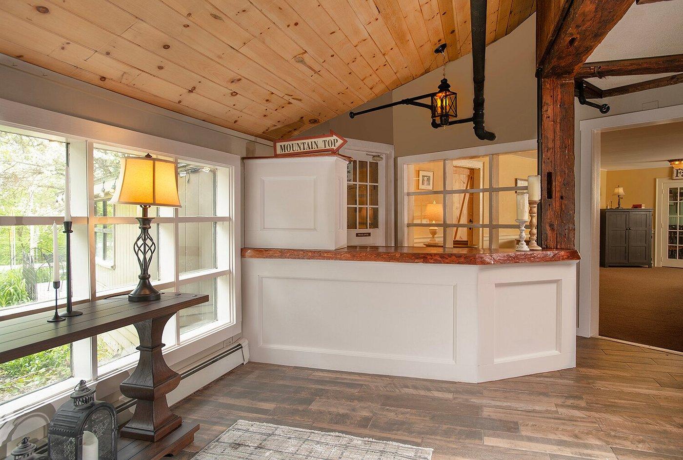 Cozy reception area with wooden ceiling and large window.