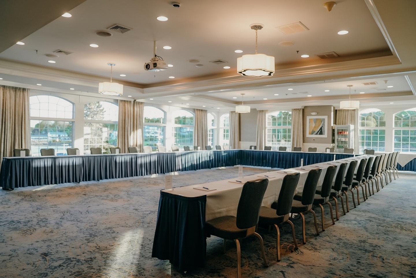 Spacious conference room with U-shaped table setup and large windows.