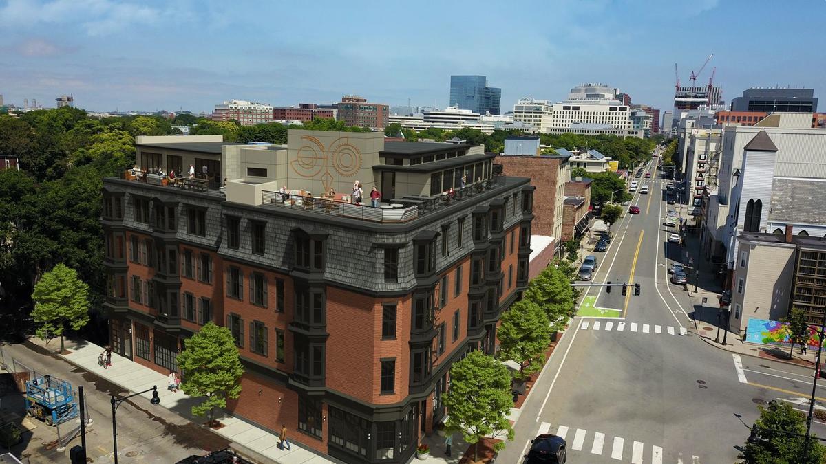 Aerial view of a brown brick building on a city street corner.
