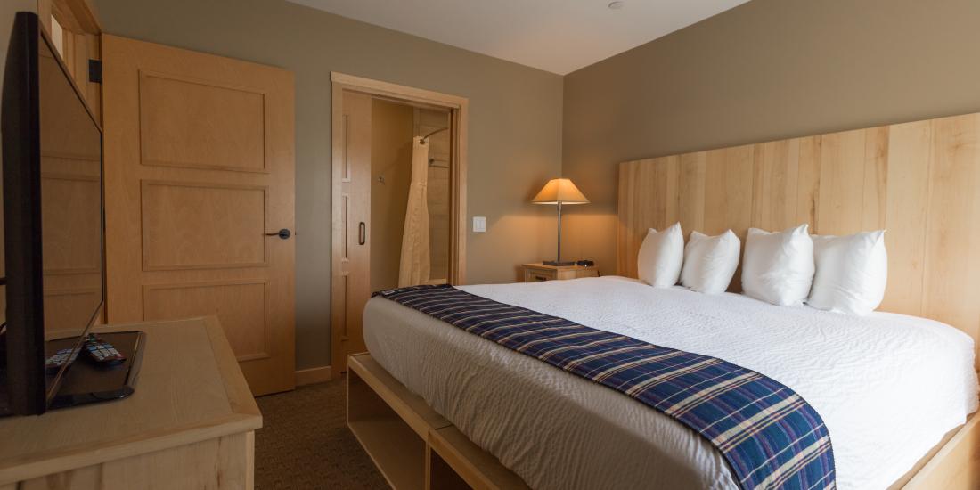 Cozy hotel room with a neatly made bed and warm lighting.