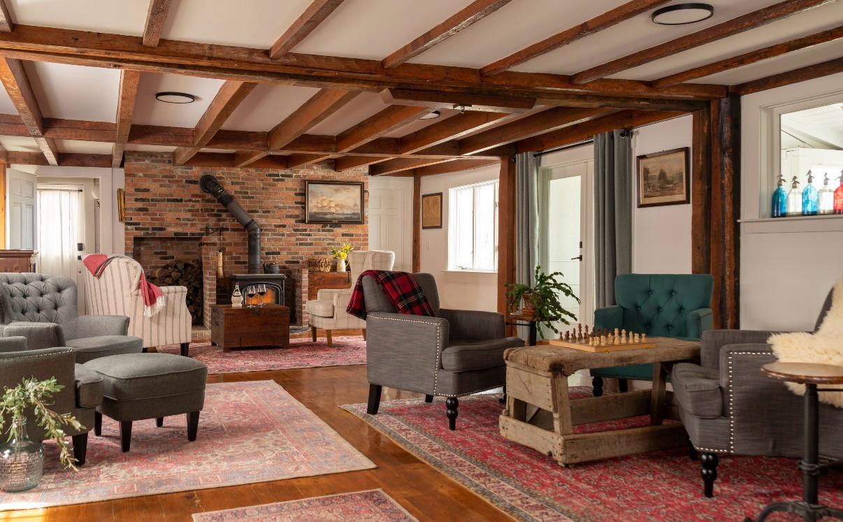 Cozy living room with vintage decor, armchairs, and a brick fireplace.