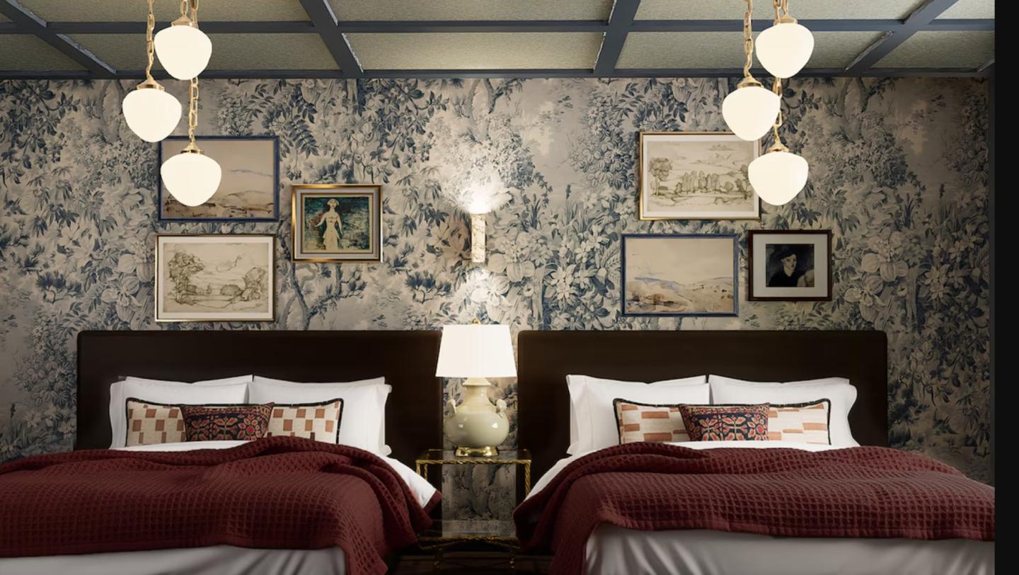 Two neatly made beds with red blankets in a vintage-themed bedroom.