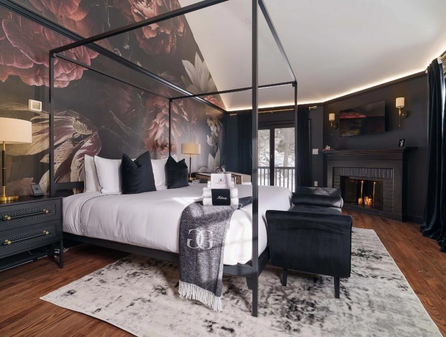 Luxurious bedroom with canopy bed, floral wallpaper, and cozy fireplace.