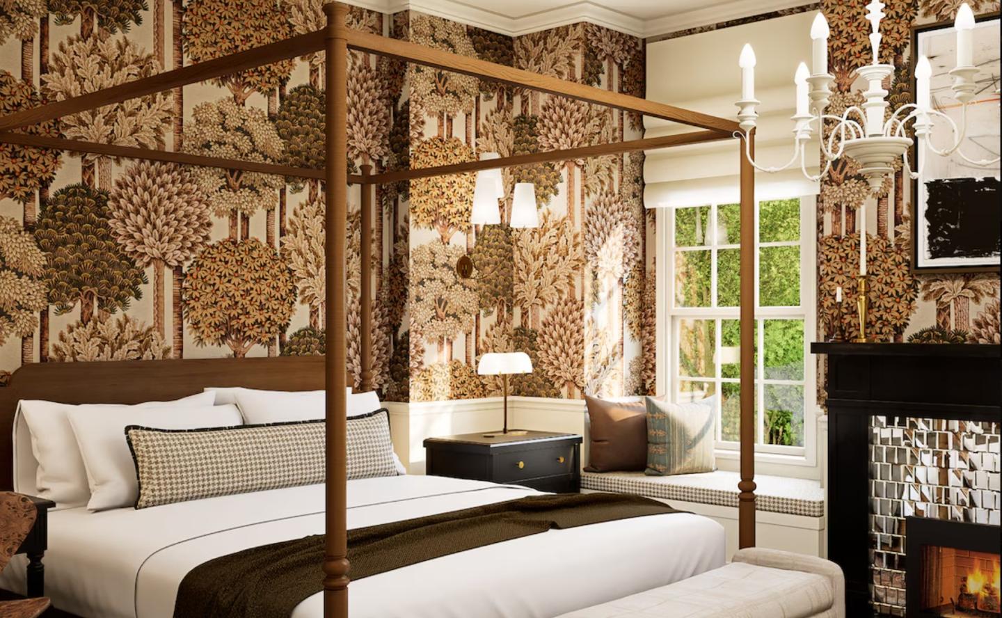 Elegant bedroom with a canopy bed, floral wallpaper, and lit fireplace.