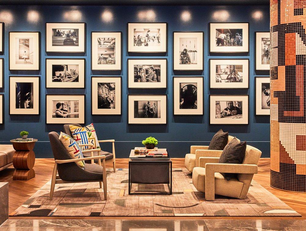 Cozy lounge with armchairs and a photo-filled wall.