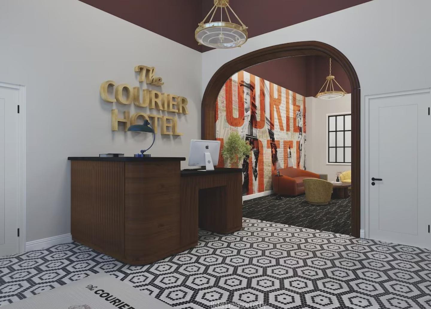 Hotel lobby with desk, patterned floor, and archway to a colorful lounge.