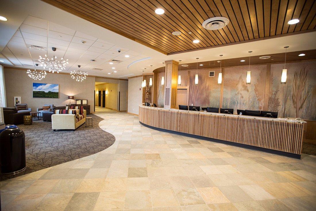 Lobby with modern decor, chandelier, and a curved reception desk.