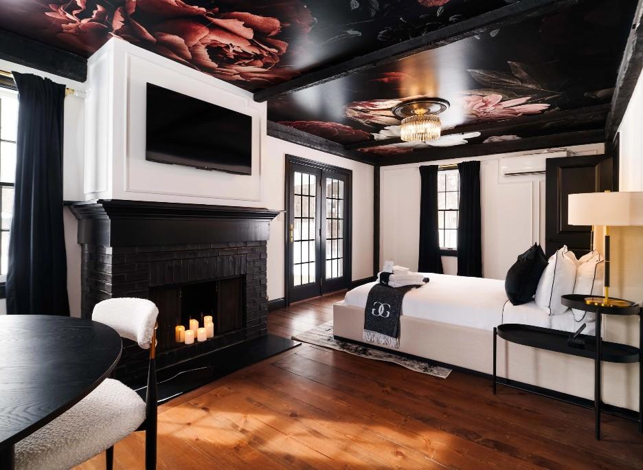 Elegant hotel room with floral ceiling, fireplace, and large windows.