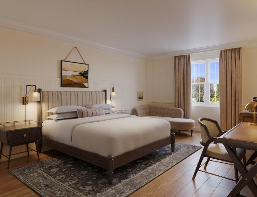 Cozy bedroom with a double bed, sofa, desk, and window with curtains.