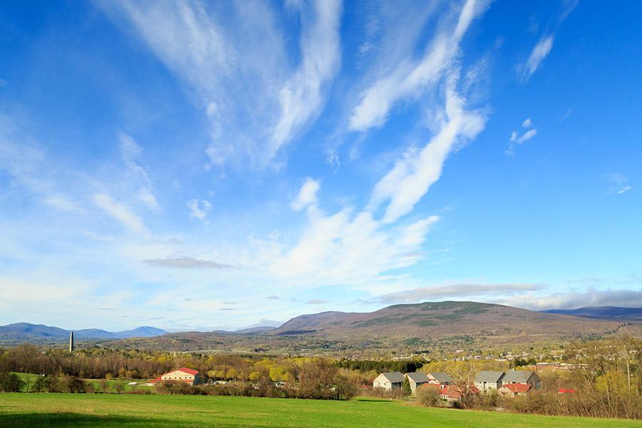 Countryside landscape with blue sky and scattered clouds.