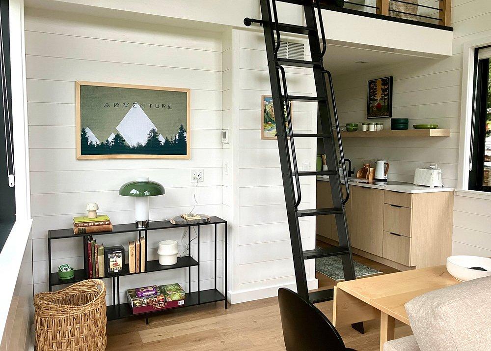Cozy loft interior with a black ladder, shelves, and artwork.