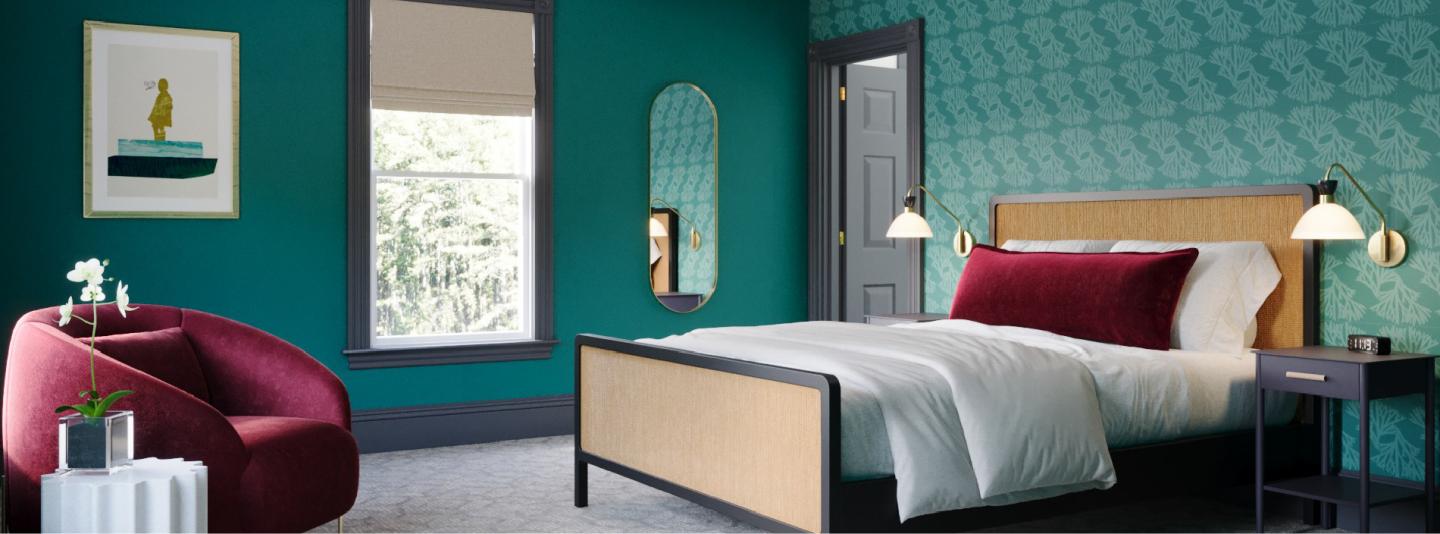 Stylish bedroom with teal walls, a bed, and a burgundy chair.