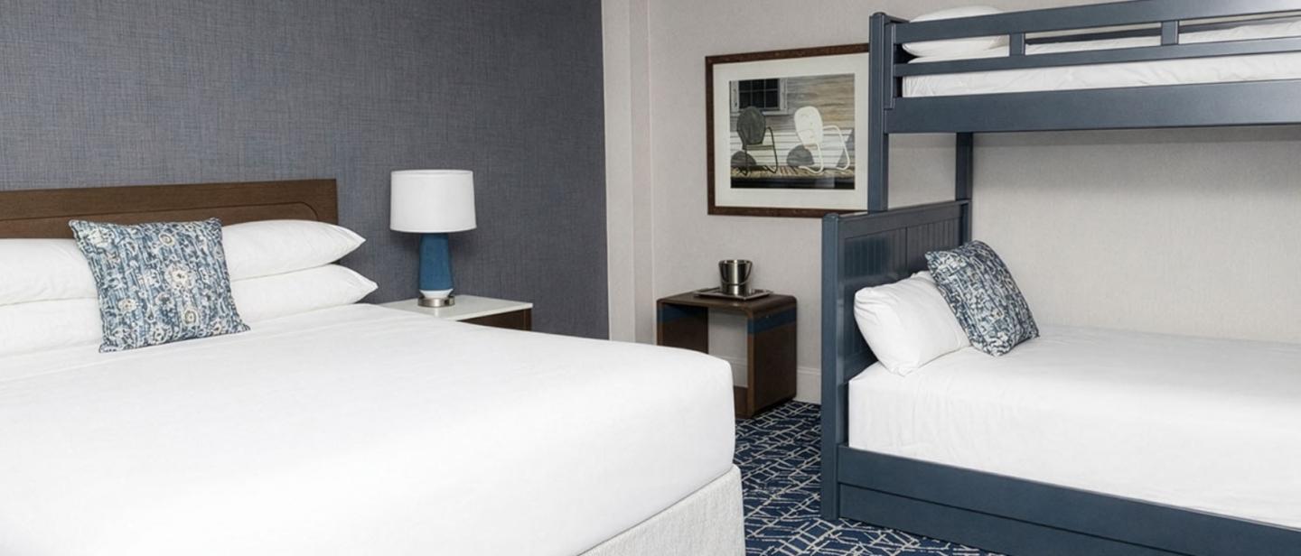 Two beds in a hotel room with blue and white decor.