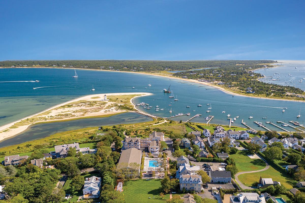 Aerial view of a coastal town with harbor and sailboats.