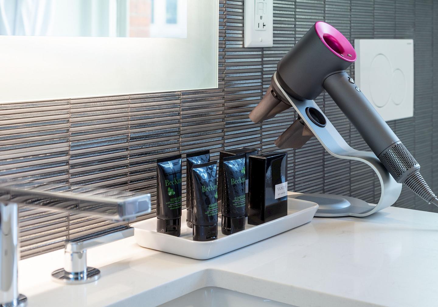 Hairdryer and toiletries on a modern bathroom counter.