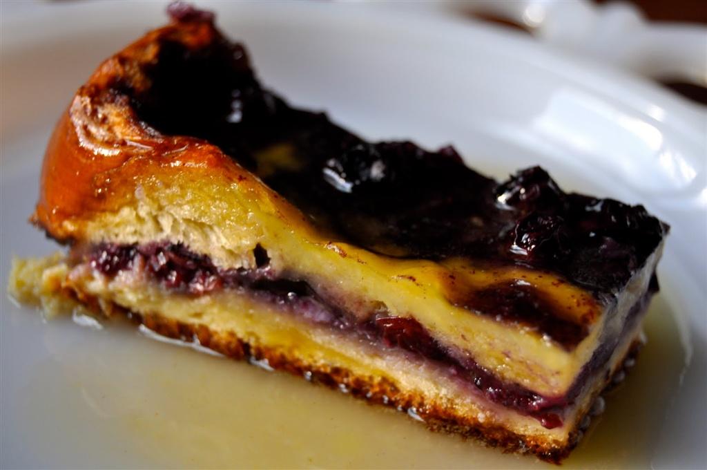 Slice of blueberry cheesecake on a white plate.