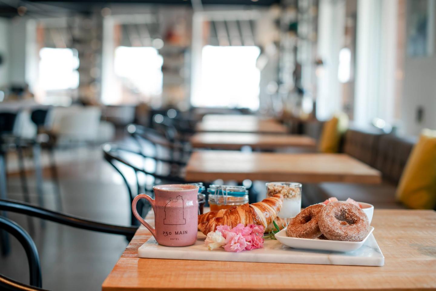 Coffee and pastries on a wooden table in a cozy cafe.