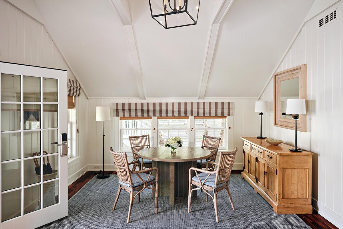 Cozy dining room with round table, four chairs, and a wooden cabinet.