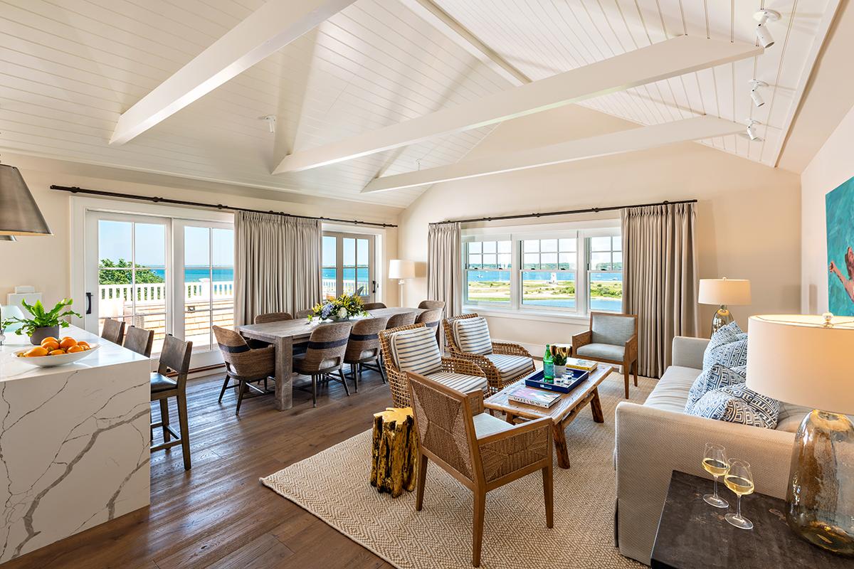Spacious living room with ocean view, modern decor, and wooden furniture.
