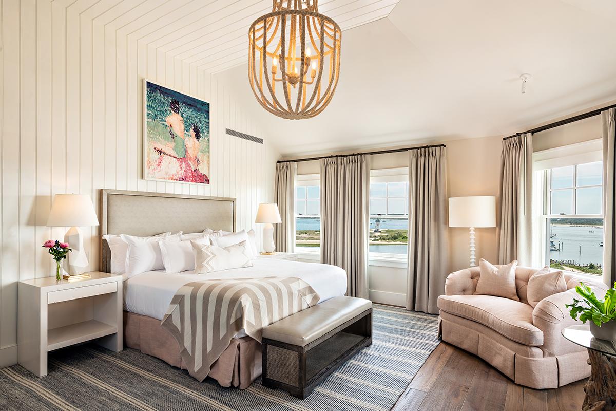 Elegant bedroom with a large bed, chic decor, and ocean view windows.