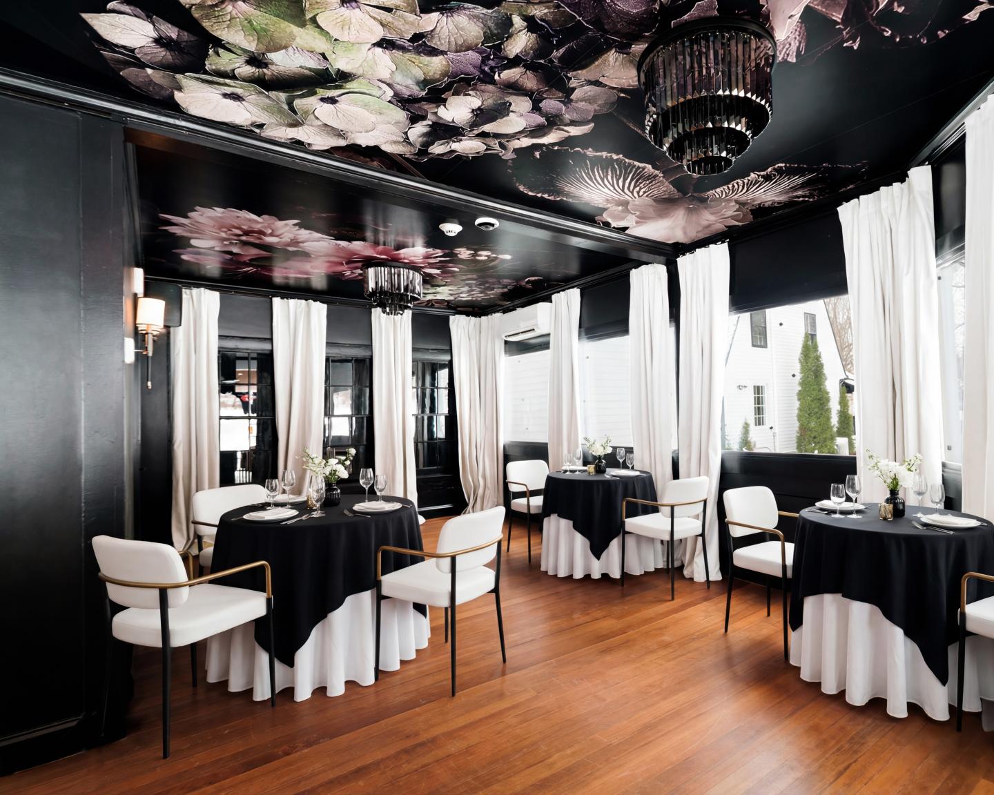 Elegant dining room with black floral ceiling and white curtains.