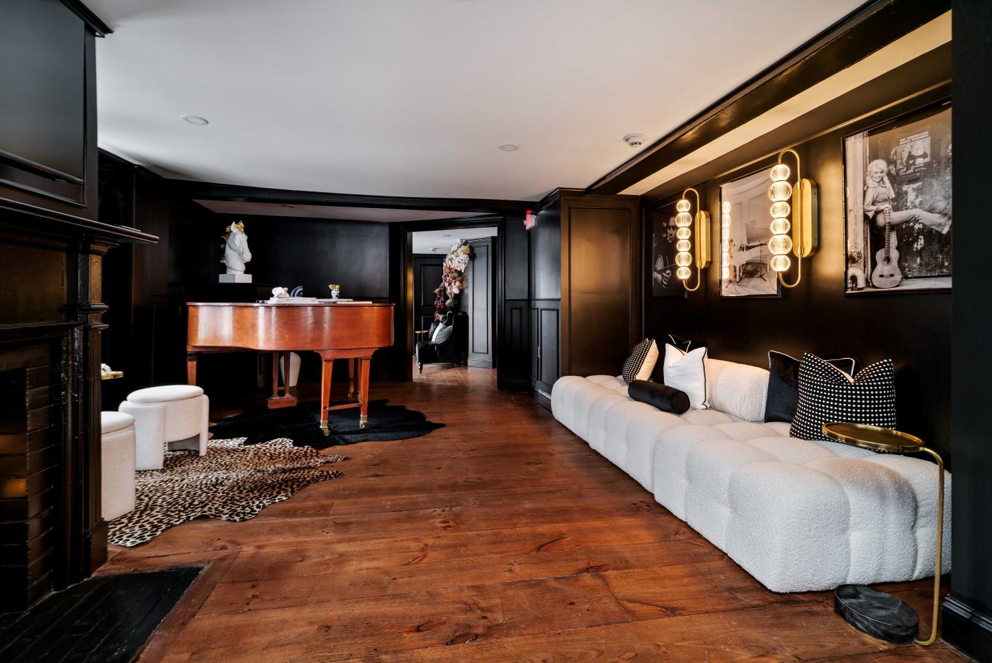 Elegant room with a white sofa, grand piano, and dark walls.