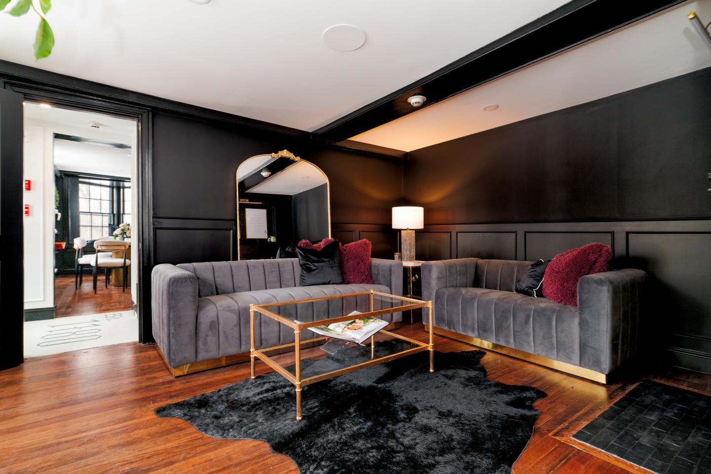 Luxurious living room with gray sofas, gold accents, and a black rug.