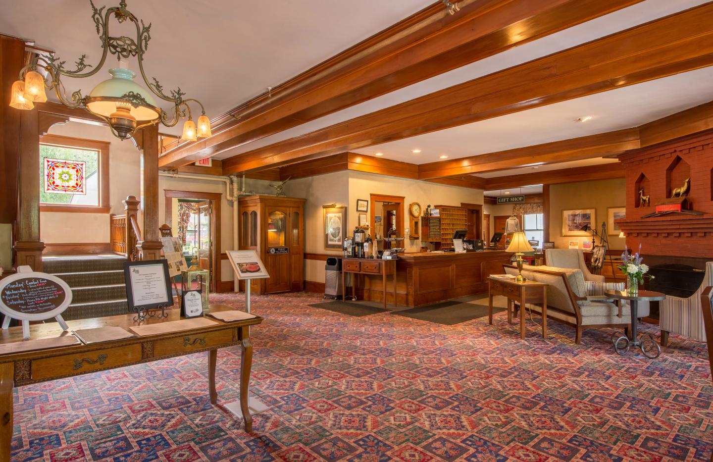Cozy hotel lobby with wooden beams and warm lighting.