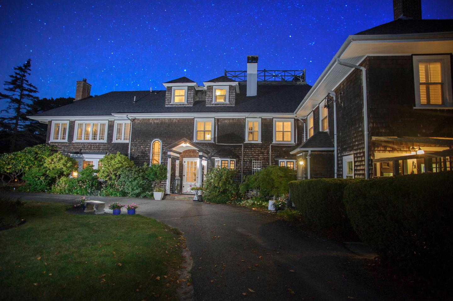 Nobnocket Boutique Inn with lit windows under a starry night sky.