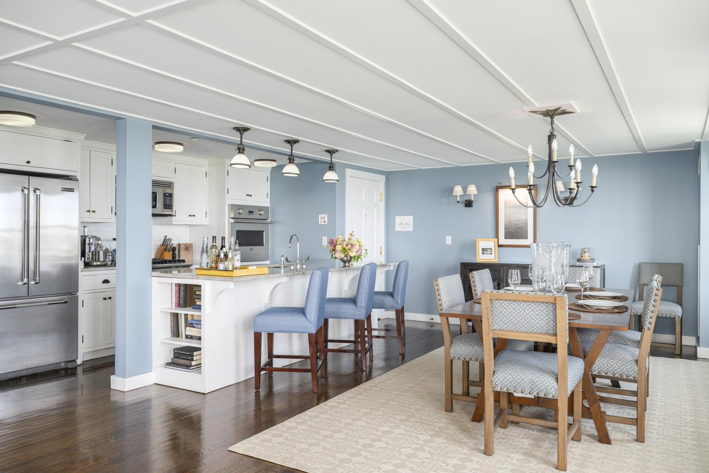 Open kitchen and dining area with blue walls and wood floors.