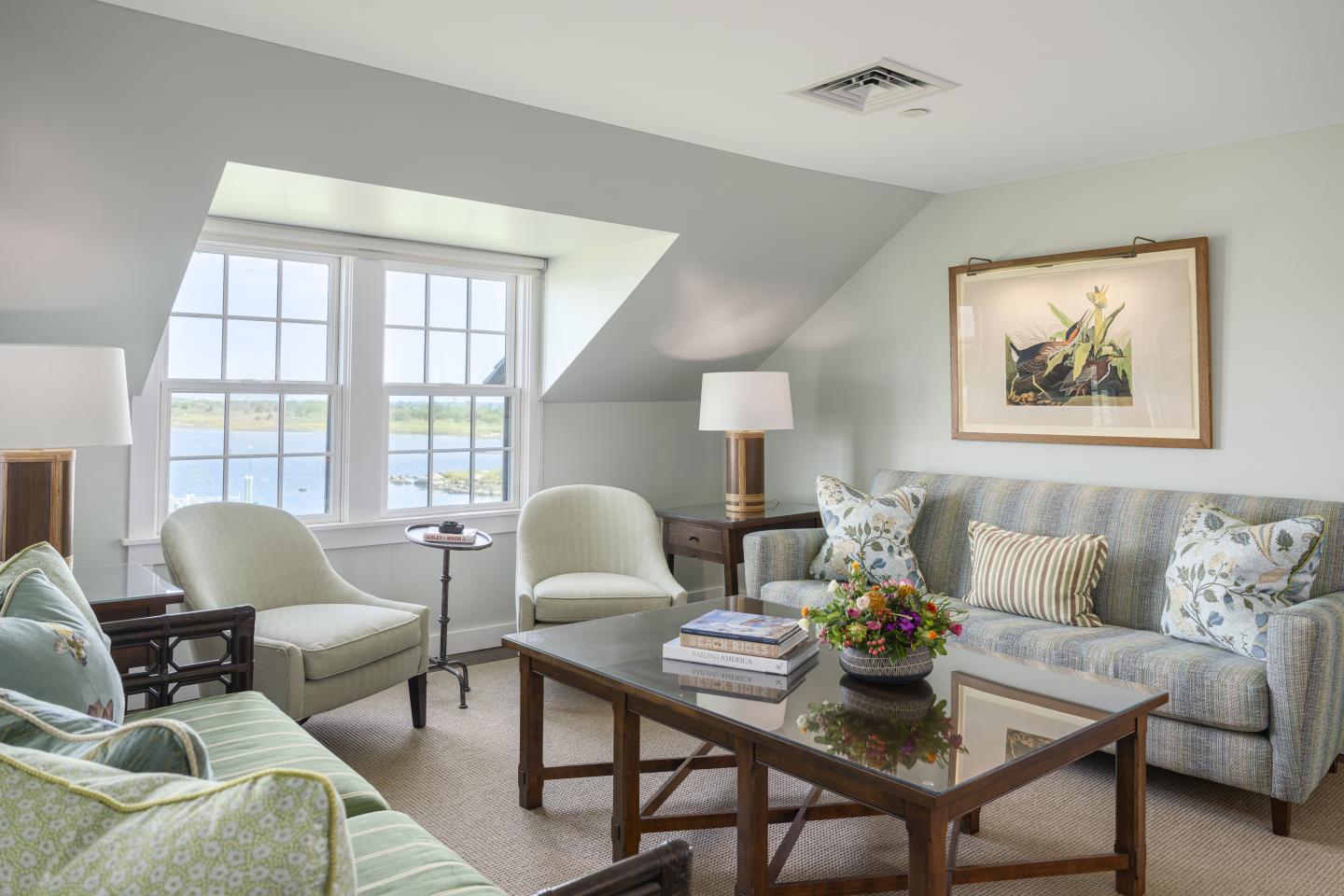 Cozy living room with sofas, armchairs, and a large window.