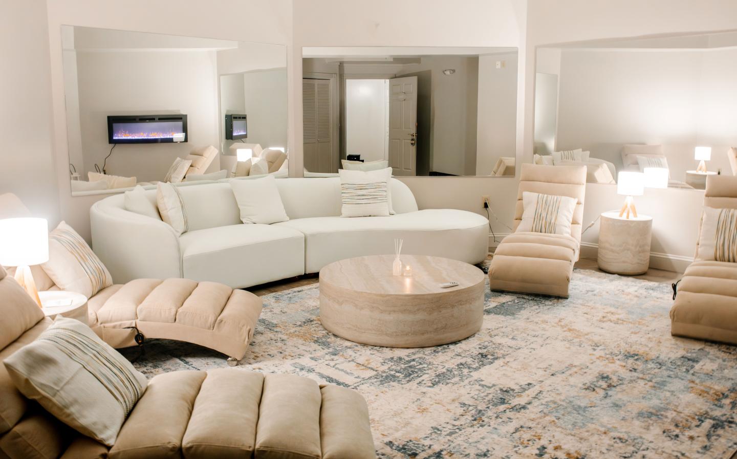 Elegant living room with beige sofas, round coffee table, and soft lighting.