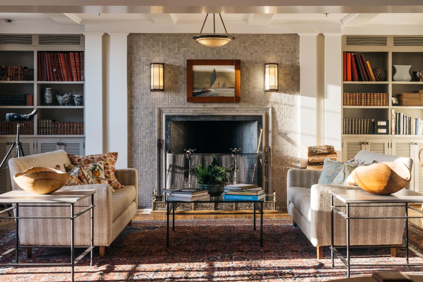 Cozy living room with sofas, fireplace, and bookshelves.