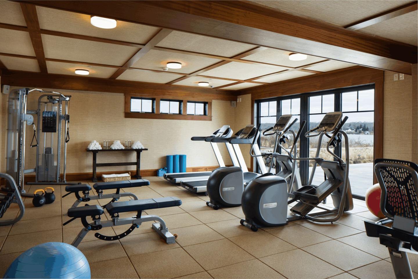 Fitness room with treadmills, weights, and exercise equipment.
